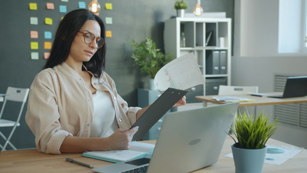 Empresaria revisando documentación y coordinando su operación logística en notebook